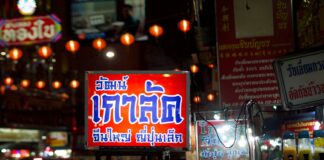 Nocna ulica w Bangkoku z neonami i tętniącym życiem targiem street foodu