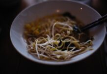 Najlepsze zupy Azji Południowo‑Wschodniej: od tom yum po laksa, gdzie ich szukać w podróży Zbliżenie na azjatycką zupę z makaronem i kiełkami w ceramicznej misce